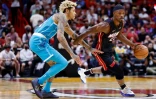 Jimmy Butler, joueur du Miami Heat, attaque face à Kelly Oubre Jr. des Charlotte Hornets en NBA, le 29 octobre 2021 à Miami