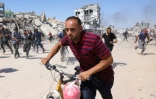 Des Palestiniens courent se mettre à l’abri lors d’une frappe de drone israélien à Jabalia, dans le nord de la bande de Gaza, le 23 mai 2025