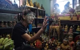 Wanchai ?Jojo? Pongsompetch assise au milieu de sa collection de poupées "Fils doré", le 18 mai 2020 à Bangkok, en Thaïlande