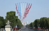 L'un des Alpha Jet de la Patrouille de France lâche une fumée rouge au lieu d'une fumée bleue à l'ouverture du défilé militaire du 14 juillet 2018 sur les Champs-Elysées à Paris