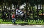 Militant pro-Trump et forces de l'ordre à vélo devant l'hôtel où les conservateurs tiennent leur grand-messe annuelle à Orlando, en Floride, le 28 février 2021