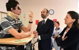 Edouard Philippe et la ministre de la Santé Agnès Buzyn s'entretiennent avec un accidenté de la route au Centre de l'Arche à Saint-Saturnin (Sarthe), le 16 mars 2018
