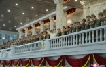 Photo fournie le 26 avril 2022 par l'agence nord-coréenne Kcna du dirigeant nord-coréen Kim Jong Un (c) assistant à une parade militaire à Pyongyang, le 25 avril 2022