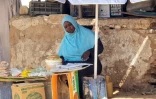 Une femme vend des produits alimentaires sur un étal dans une rue d'un marché de Khartoum, au Soudan, le 21 mai 2023