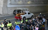 Des personnes saluent le passage du cercueil du pape François transporté en papamobile de la basilique Saint-Pierre à à la basilique Sainte-Marie-Majeure, lors de la cérémonie funéraire au Vatican, à Rome, le 26 avril 2025