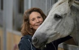 Reha Hutin, présidente de la Fondation 30 Millions d'amis, caresse un cheval au refuge de la Fondation, le 9 septembre 2021 à Bannegon, dans le Cher