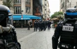 Des policiers se tiennent à côté d'un restaurant en feu lors d'une manifestation à Paris, le 10 septembre 2025