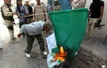 Des rebelles libyens brûlent le drapeau vert adopté par l'ancien leader libyen Muammar Kadhafi, lors des combats pour la prise de la ville de Syrte, le 8 octobre 2011
