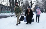 Un soldat ukrainien aide une femme âgée à transporter ses effets personnels vers une tente dressée pour les résidents de la ville d'Avdiïvka, le 31 janvier 2017