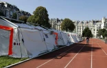 Des migrants jouent au foot devant des tentes installées par la Sécurité civile sur un terrain de sport dépendant de l'Université Panthéon-Assas le 22 août 2017 