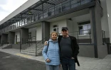 Maryna et son époux Volodymyr, déplacés par la guerre, posent devant un bâtiment rénové dans la ville de Slavoutytch dans le nord de l'Ukraine, le 25 avril 2026 