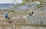 Construction d'une maison pour accueillir des déplacés climatiques, dans le district de Khourosson, le 26 mars 2024 au Tadjikistan