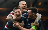 La joie du milieu de terrain écossais Callum McGregor (g), félicité par Andrew Robertson (d) et Lyndon Dykes, après avoir égalisé (1-1) contre la Croatie, lors de la 3e journée du groupe D à l'Euro 2020, le 22 juin 2021 à Glasgow 