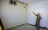 Mustafa Khaled Alwan montre l'emplacement du faux mur qui dissimulait sa bibliothèque, chez lui à Homs, en Syrie, le 19 septembre 2026