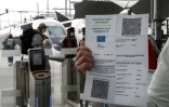 Un passager présente son pass sanitaire avant d'accéder au quai, lundi 9 août 2021, gare de Lyon à Paris

