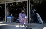 Un homme assis devant un magasin de pièces automobiles, dans un marché situé près d'un poste-frontière entre l'Afghanistan et le Pakistan, dans le district de Spin Boldak, le 29 décembre 2025