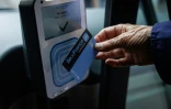 Un passager utilise son pass navigo, le forfait mensuel des transports publics en Ile-de-France, pour valider son trajet à bord du bus de la ligne 85 exploitée par la RATP à Paris, le 31 juillet 2026