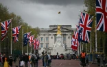 Des promeneurs sur le Mall décoré de drapeaux, le 28 avril 2023 à Londres, avant le couronnement du roi Charles III