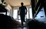 Le soldat ukrainien d'origine géorgienne, Daviti Souleymanishvili, amputé de la jambe gauche, utilise des béquilles dans l'appartement d'un ami, le 24 mai 2022 à Kiev