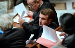 Emmanuel Macron (C) devant Jean-Yves Le Drian le 9 décembre 2014 à l'Assemblée nationale à Paris