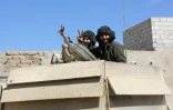 Des combattants progouvernementaux font le signe de la victoire dans la ville reconquise de Mohamadiyé, dans la Ghouta orientale, le 7 mars 2018