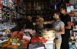 Des Syriens font leurs emplettes dans un magasin de la ville de Binnish contrôlée par les rebelles dans la province d'Idleb dans le nord-ouest de la Syrie, le 15 octobre 2018