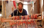 Un homme tisse un tapis traditionnel dans une échoppe du marché de Hilla, le 12 octobre 2017 en Irak