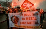 Des employés d'ArcelorMittal défilent derrière une banderole lors d'une action organisée par la CGT sur l'Esplanade des Invalides, à Paris, le 27 novembre 2025
