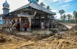 Des villageois tentent de nettoyer leur mosquée endommagée par les inondations à Aek Garoga dans le nord de l'île indonésienne de Sumatra, le 4 décembre 2025