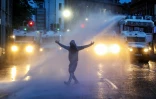 La police utilise un canon à eau pour disperser les manifestants lors d'une troisième nuit d'émeutes visant les immigrés à Ballymena, en Irlande du Nord, le 11 juin 2025