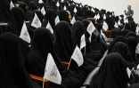 Des étudiantes afghanes en niqab noir écoutent un discours lors d'un rassemblement pro-talibans à l'université Shaheed Rabbani, le 11 septembre 2021 à Kaboul