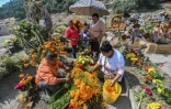 Des proches décorent la tombe d'un parent décédé au cimetière de Valle de Chalco, le 28 octobre 2020 au Mexique