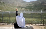 Une femme druze salue de la main des proches fuyant les violences près de Damas, après leur arrivée dans la zone tampon en face du village de Majdal Shams sur les hauteurs de la partie du Golan occupée par Israël, le 3 mai 2025