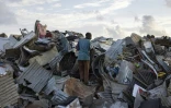 Dans une décharge de Mamoudzou, un homme cherche des tôles pour reconstruire sa maison le 28 décembre 2024