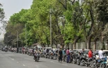 Des motocyclistes et des automobilistes font la queue pour prendre de l'essence à Dacca, le 8 mars 2026 au Bangladesh