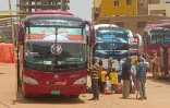 Des habitants, fuyant les combats entre l'armée et les paramilitaires, s'apprêtent à monter dans un bus pour quitter Khartoum, le 27 avril 2023 au Soudan