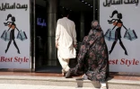 Un homme et une femme entrent dans un centre commercial, le 1er juillet 2026 à Hérat, dans l'ouest de l'Afghanistan 