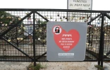 Une affiche de la mairie pour dissuader les touristes d'accrocher des "cadenas d'amour", le 4 août 2016 sur le Pont Neuf à Paris