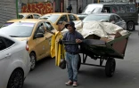Jesus Maria Perez tire sa charrette remplie de déchets à recycler dans les rues de Bogota, le 25 mai 2022 