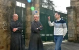 Le maire de Solignac, Alexandre Portheault (D), discute avec le père Benoît Joseph (C) et le père André à la porte de l'abbaye de Solignac, en Haute-Vienne, le 21 mars 2024