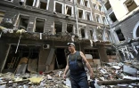 Un ouvrier dans une cour au milieu des débris après une attaque contre un centre commercial et des bureaux dans le centre de Kharkiv, le 27 juillet 2022

