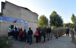 Des habitants et des militaires patientent devant un centre de vote élections législatives kizghizes dans le village de Bech-Kungey, près de Bichkek, le 4 octobre 2020