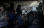 Des membres du Cabinet médical de rue parlent avec des sans-abris dans un campement sous un pont, dans les environs de Rio de Janeiro, le 31 juillet 2023 au Brésil