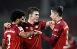 L'attaquant polonais du Bayern Munich, Robert Lewandowski, est félicité par le défenseur français Benjamin Pavard et le milieu de terrain Serge Gnabry, après avoir marqué le 4e but sur le terrain de Stuggart, lors de la 16e journée de Bunesliga, le 14 décembre 2021