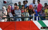 Des migrants attendent d'être débarqués d'un bateau des guardes-côtes italiens à leur arrivée le 7 auût 2015 à Pozzalo en Italie