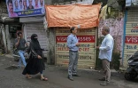 Ullesh Gajakosh (d), organisateur de la campagne "Sauvons Dharavi" dans une rue du bidonville de Bombay, le 8 juillet 2025 en Inde