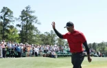 L'Américain Tiger Woods salue la foule, massée autour du 18e trou, après avoir terminé son dernier tour du Masters, le 10 avril 2022 sur le parcours d'Augusta (Géorgie)