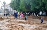 Une famille marche dans une rue envahie par la boue après les inondations qui ont touché la région de Valence, le 30 octobre 2024 à Picanya, en Espagne