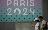 Une femme s'évente sous la chaleur pendant les JO-2024 devant l'Arena Paris Sud à Paris, le 29 juillet 2024