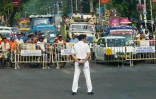 Un policier monte la garde devant une barrière pour réguler la circulation alors que le cortège du secrétaire d'Etat américain Marco Rubio passe à Calcutta, le 23 mai 2026